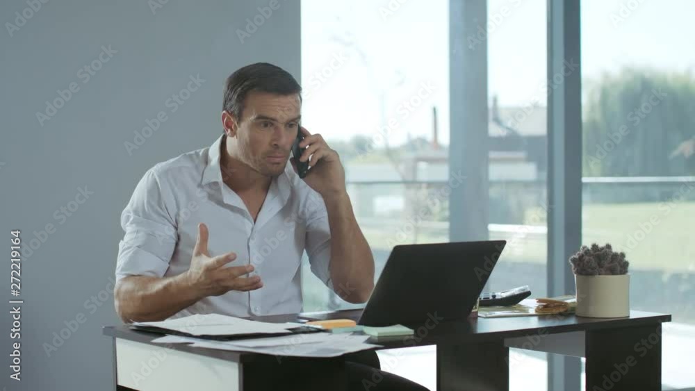 Business man yelling on mobile phone in house. Angry man screaming on phone. Business man yelling on mobile phone in house. Angry man screaming on phone.