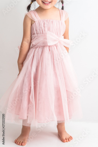 白背景にピンクのキッズドレスを着た女の子が座っているプリンセスお姫様