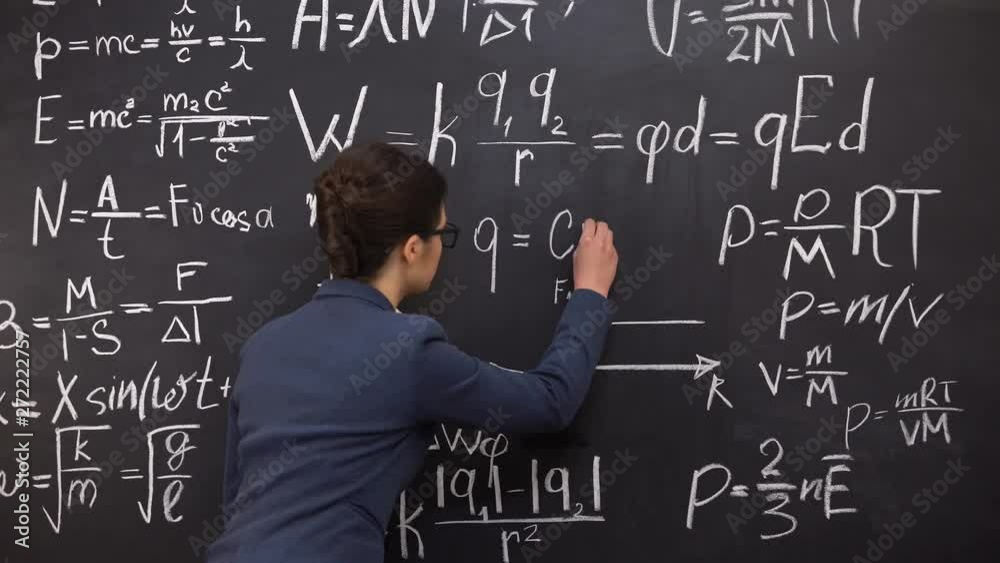 Female tutor writing formula on chalkboard, mathematics lecture, exact sciences
