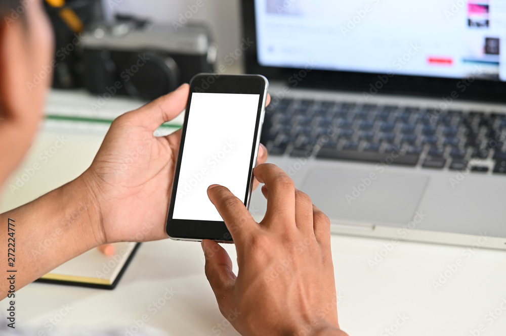 Cropped shot hands using mockup mobile phone on office desk. Cropped shot hands using mockup mobile phone on office desk.