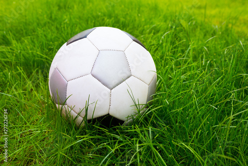 A football ball at the field background of thick green grass  a close-up.