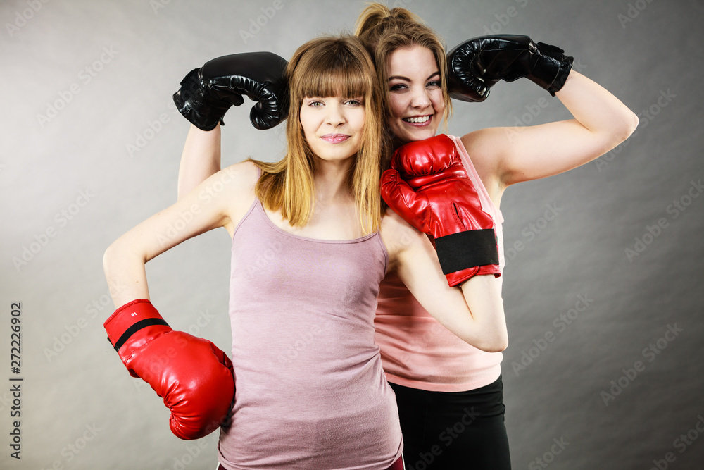 Two women friends wearing boxing gloves Two women friends wearing boxing gloves