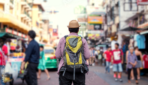 Young asian traveller man walking in Khaosan Road walking street in bangkok thailand on vacation time.