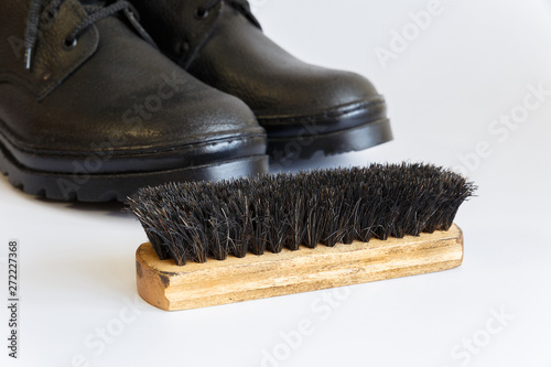 Black shoes and Shoe brush on white background. Shoe care with a brush. Shoe brush. No people.