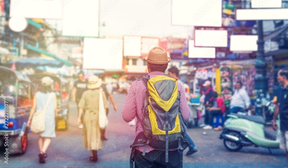 Young asian traveller man walking in Khaosan Road walking street in bangkok thailand on vacation time.