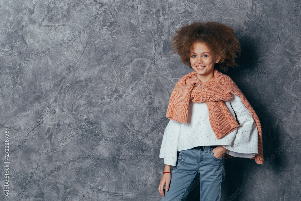 Headshot Portrait Sweet little girl with curly hair smiling looking at camera. gray background. Headshot Portrait Sweet little girl with curly hair smiling looking at camera. gray background.