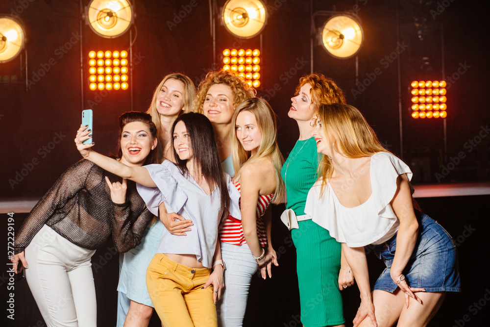 friends with smartphone taking selfie in club, Stock image