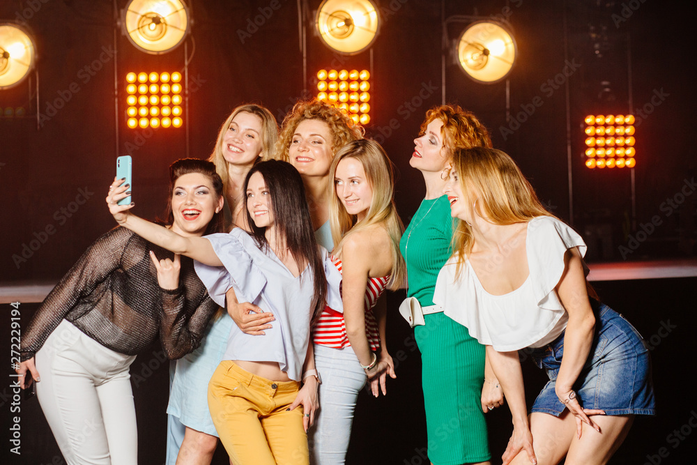 party, technology, nightlife and people concept - smiling friends with  smartphone taking selfie in club. Stock Photo