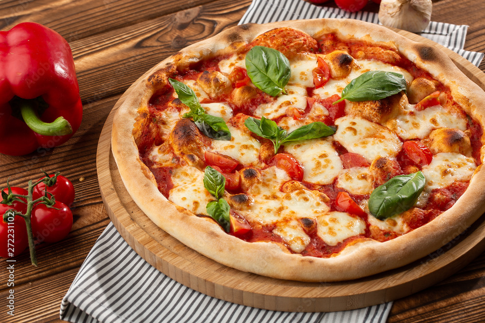 Pizza Margherita on wooden background, top view. Pizza Margarita with Tomatoes, Basil and Mozzarella Cheese close up.