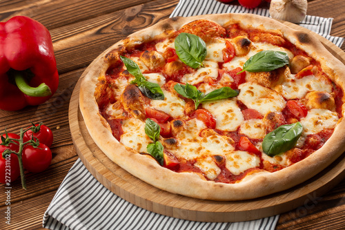 Pizza Margherita on wooden background, top view. Pizza Margarita with Tomatoes, Basil and Mozzarella Cheese close up. 