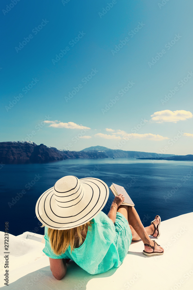 Obraz premium Luxury travel vacation woman looking at view on Santorini island