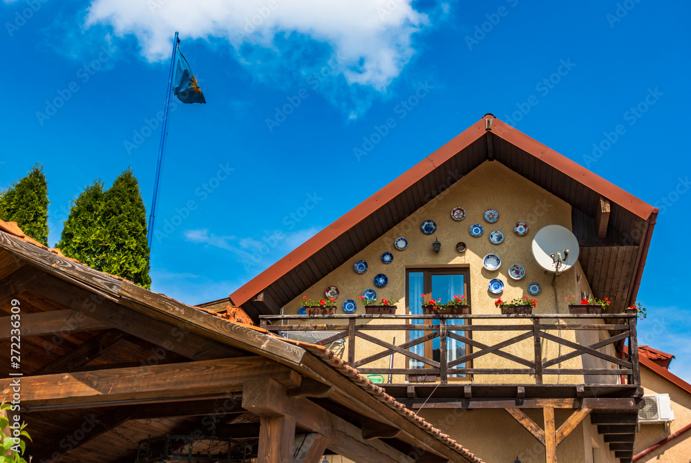 The facade of the second floor of the house with a wooden balcony - obrazy, fototapety, plakaty 