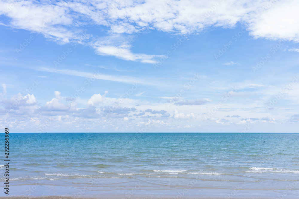 Yellow warm sand and summer sea with blue sky and copy space. Sea view during daytime with blue sky and white clouds. Summer season concept.