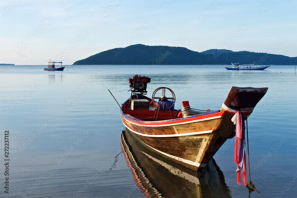 old wooden thai traditional fishing boat is reflected in the water at sunset, island koh samui thailand old wooden thai traditional fishing boat is reflected in the water at sunset, island koh samui thailand