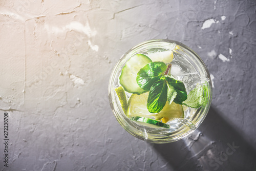 Top view of the glass with non-alcoholic vegetarian cocktail of cucumber, lemon and mint with space for text
