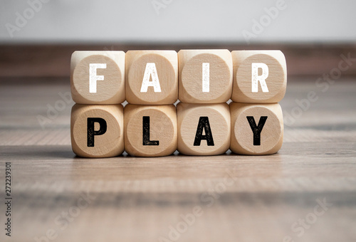 Cubes and dice with the word fair play on wooden background