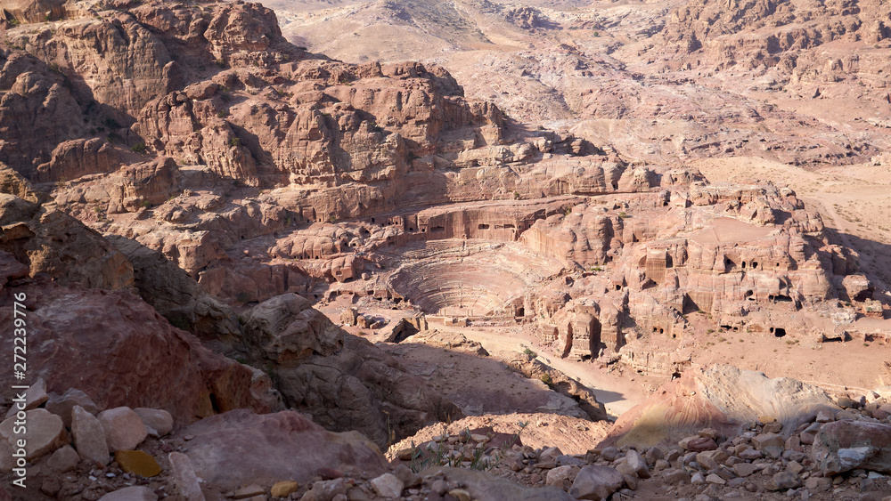 Roman Amphitheater in Petra was carved out of a solid rock. Panoramic aerial view of the red Jordan desert landscape.