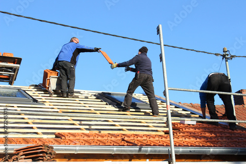 Dachdecker beim Eindecken eines Wohnhauses         photo