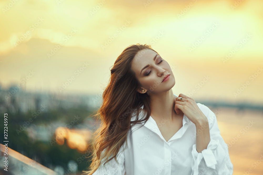 Young woman over cityscape golden sunset
