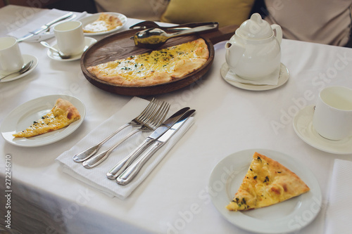 Four cheese pizza quattro fromaggi with basil leaf on a rustic wooden board background. photo