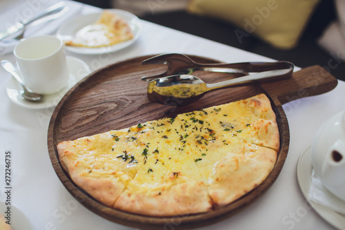 Four cheese pizza quattro fromaggi with basil leaf on a rustic wooden board background. photo