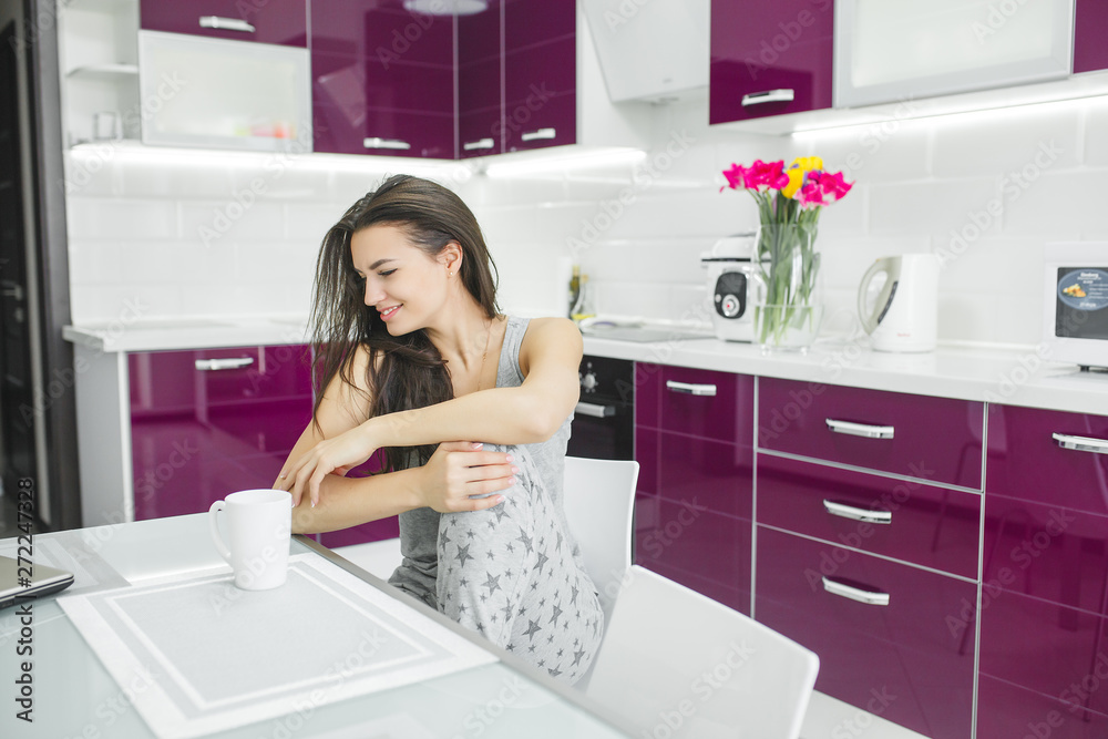 Young beautiful woman in the early morning having coffee on the kitchen. Fresh morning.  Bracing drink. Fees for work. Awake lady.