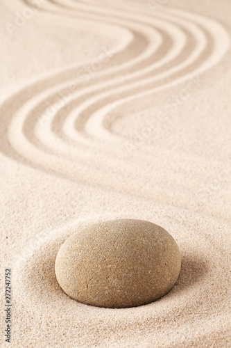 Meditation stone on sand background. Concept for zen, harmony and purity.