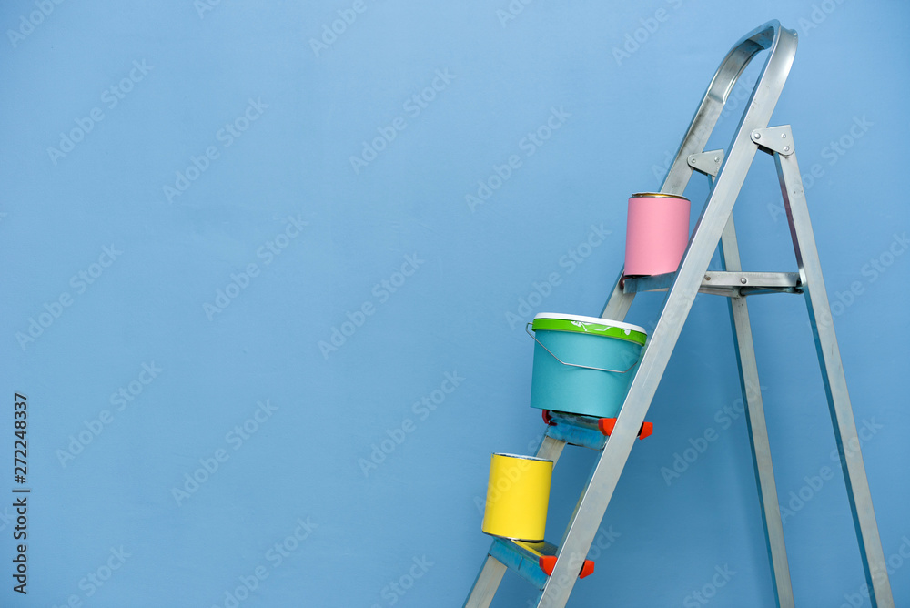 Set of tools and paints for repair in apartment on stairs on blue background.