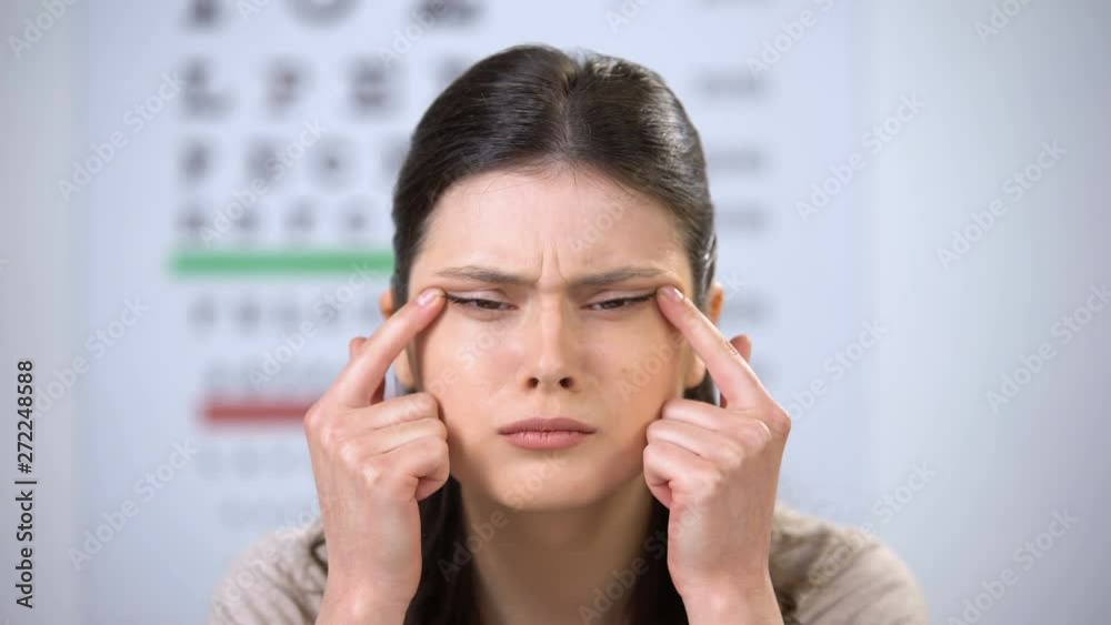 Woman with extremely poor vision squeezing eyes with fingers trying to focus Woman with extremely poor vision squeezing eyes with fingers trying to focus