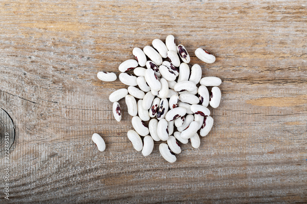 A pile of raw beans on a wooden background