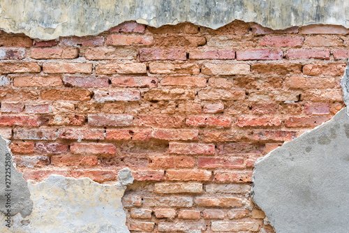 Old red bricklaying wall under cracked cement