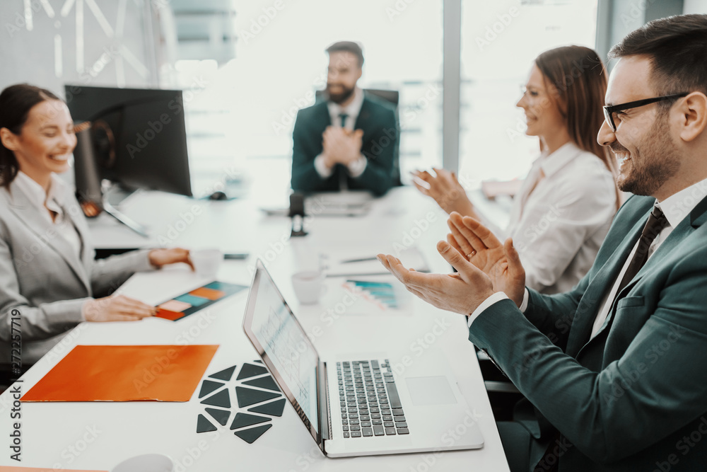 Positive dedicated business people dressed in suits clapping for successfully done job. Positive dedicated business people dressed in suits clapping for successfully done job.