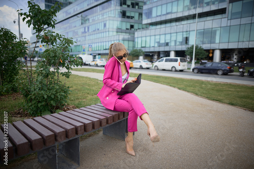 Business woman sitting on a bench in the street