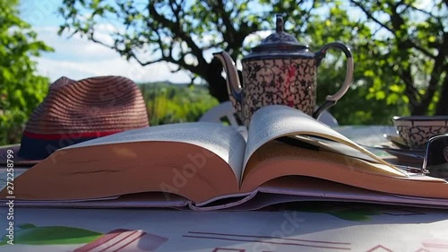 Il mio Blowing pages in the breezy wind, Book, holiday relax in the garden green with an antique teapot photo