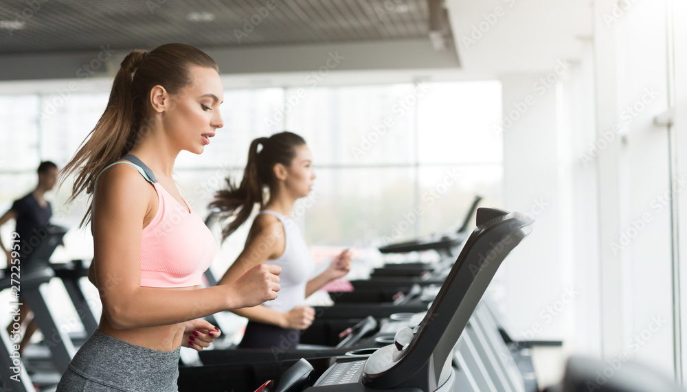 Training in gym. Women doing cardio workout on treadmill Training in gym. Women doing cardio workout on treadmill