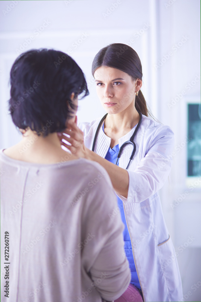 A serious female doctor examining a patient's lymph nodes A serious female doctor examining a patient's lymph nodes