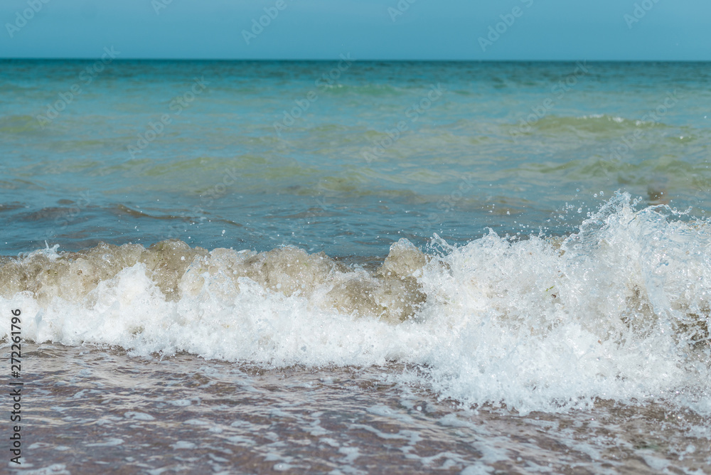Waves on the sea, ocean. View of the sea from the shore in the afternoon in summer.