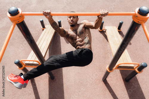 Fitness Man Doing Abs Workout On Horizontal Bar Outdoors