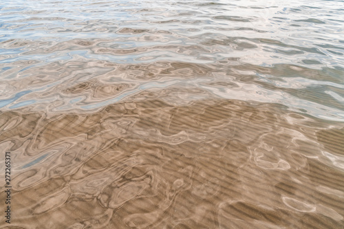 Smooth water surface with sand bottom