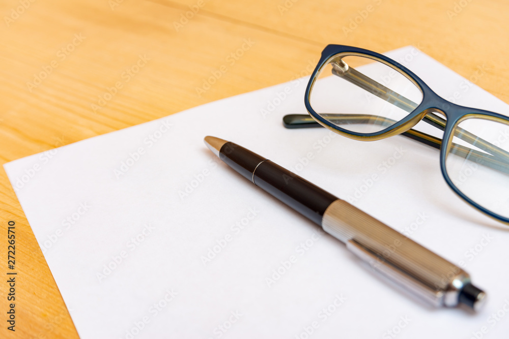Eyeglasses and a pen lie on a clean and white sheet of paper for recording. Eyeglasses and a pen lie on a clean and white sheet of paper for recording.
