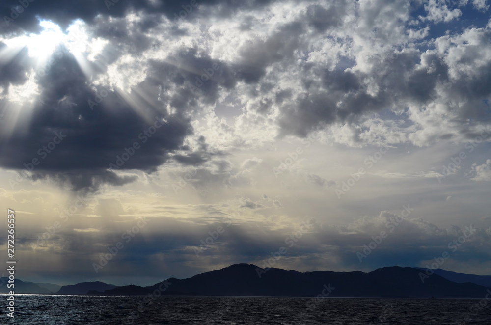 the setting sun in the clouds over the Aegean Sea
