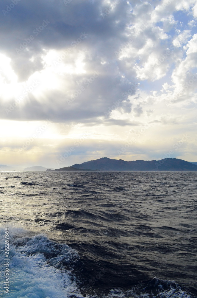 the setting sun in the clouds over the Aegean Sea