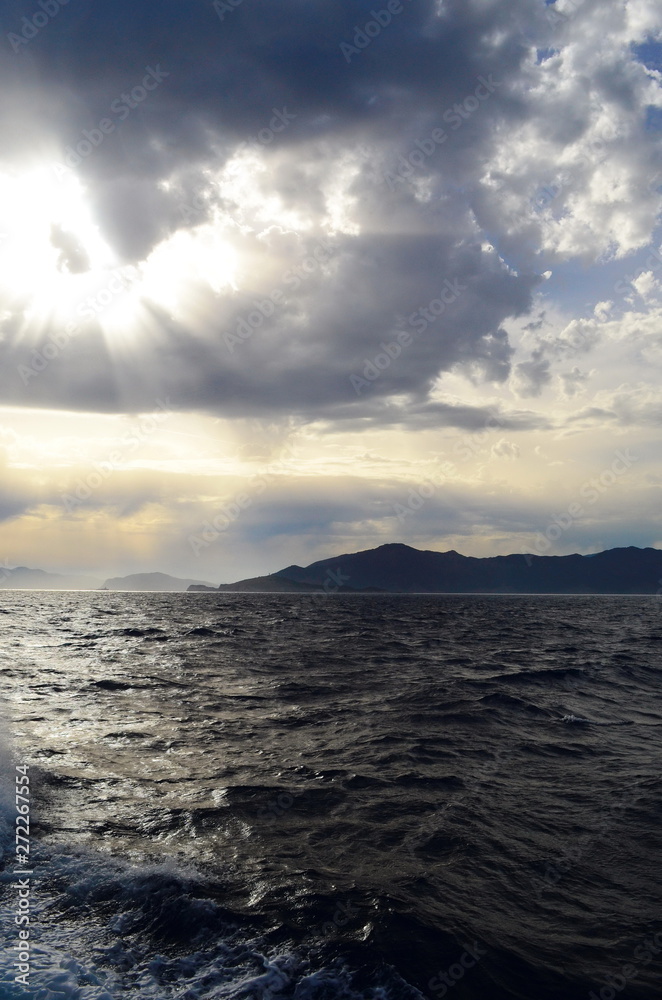 the setting sun in the clouds over the Aegean Sea the setting sun in the clouds over the Aegean Sea