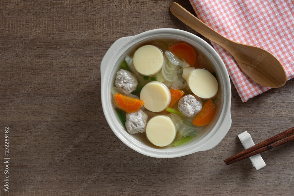 top view of egg tofu clear soup in a ceramic bowl on wooden table. asian homemade style food concept. top view of egg tofu clear soup in a ceramic bowl on wooden table. asian homemade style food concept.