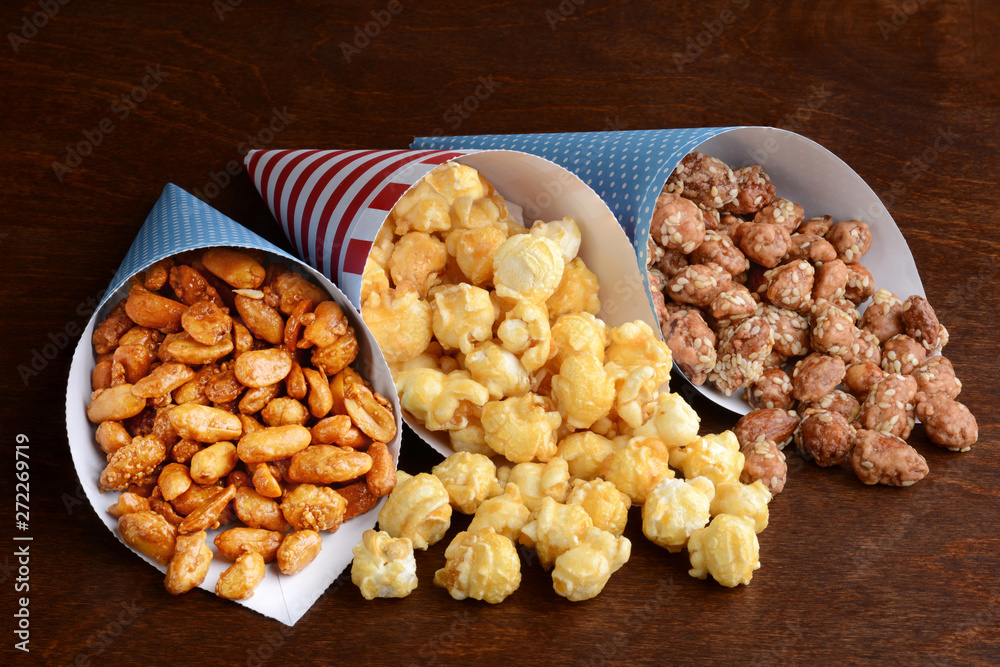 honey peanuts with caramel popcorn and closeup of honey sesame seed almonds in paper cones honey peanuts with caramel popcorn and closeup of honey sesame seed almonds in paper cones