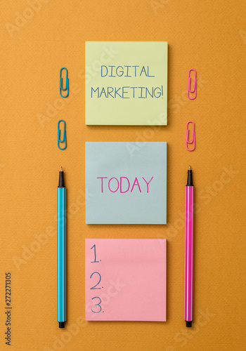 Word writing text Digital Marketing. Business photo showcasing Search Engine Optimazation Pay Per Click Ad Internet Front view blank colored sticky note two ballpoints clips yolk background photo