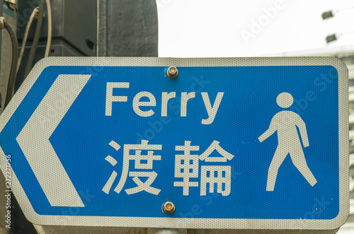 blue sign indicating the way to the ferry in Hong Kong, China