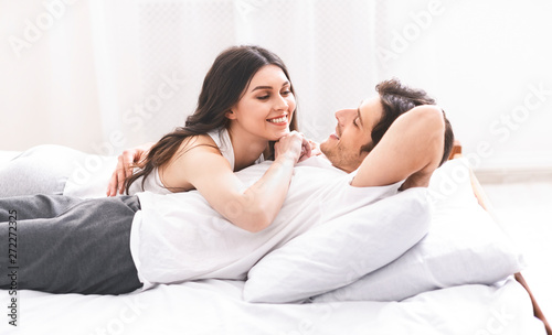 Loving couple relaxing in bed at home
