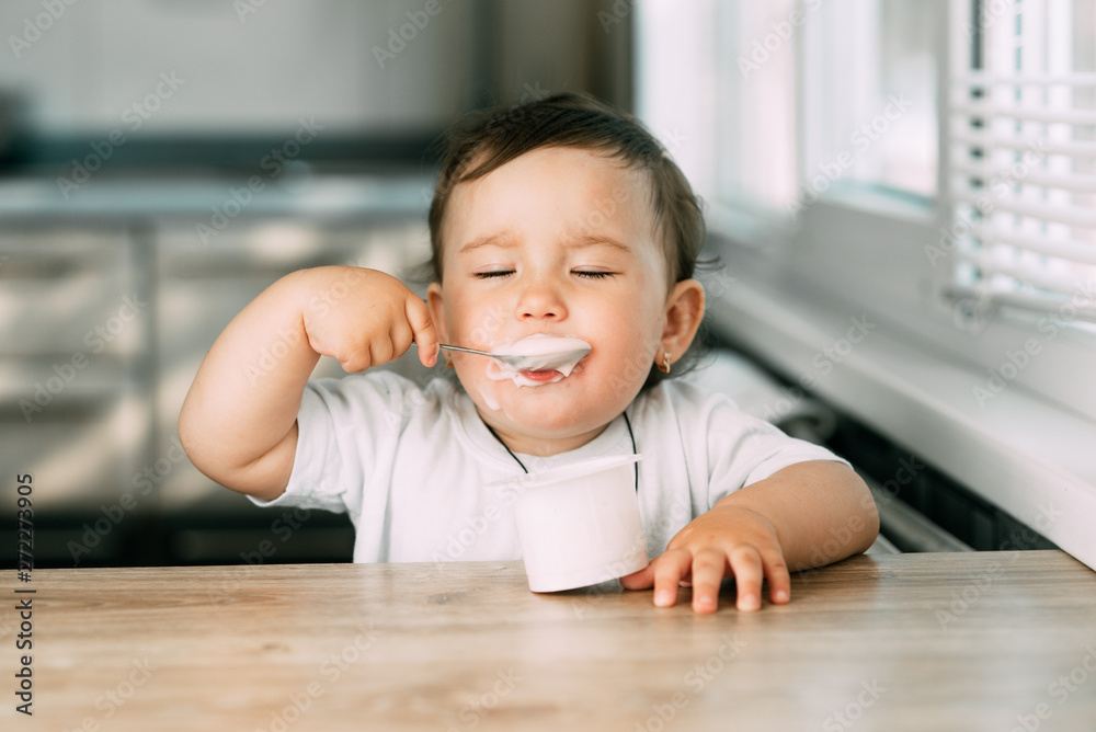 A little charming girl eats yogurt all smeared herself A little charming girl eats yogurt all smeared herself