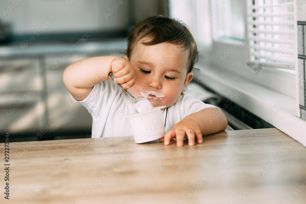 A little charming girl eats yogurt all smeared herself A little charming girl eats yogurt all smeared herself